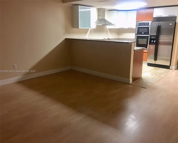 a room with granite countertop a sink and a stove top oven