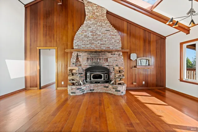 a view of a livingroom with wooden floor and a fireplace