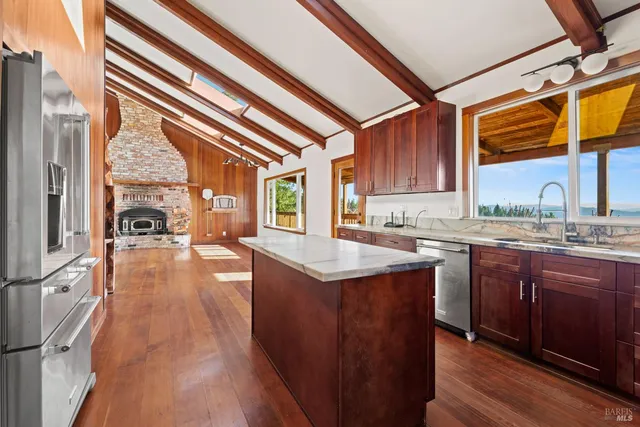 a kitchen with stainless steel appliances granite countertop a sink stove and wooden cabinets