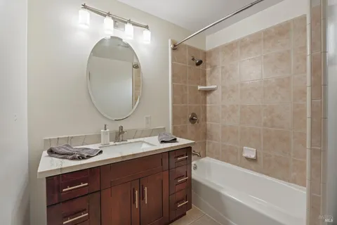a bathroom with a sink mirror and a bathtub
