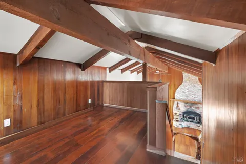 a view of a hallway with wooden floor and fence