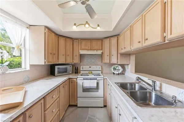 a kitchen with granite countertop a sink stainless steel appliances a window and a counter space