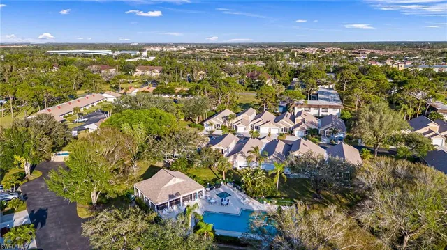 an aerial view of residential houses with outdoor space and trees