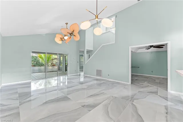 a view of a room with a chandelier fan and windows