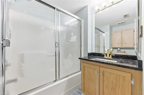 a bath room with a granite countertop sink and a mirror