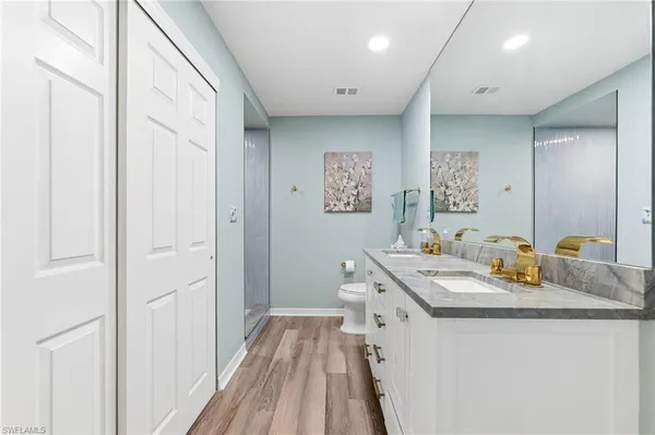 a spacious bathroom with a granite countertop sink a mirror and a shower