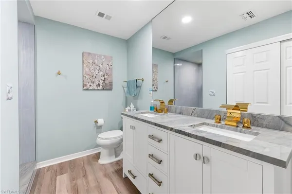 a bathroom with a sink a toilet and a mirror