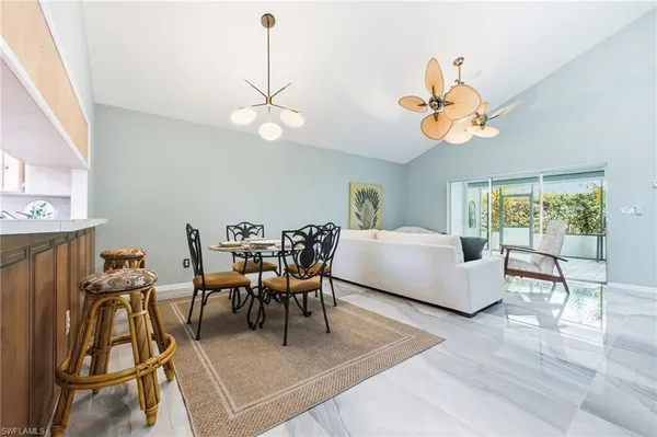 a living room with furniture a dining table and a chandelier