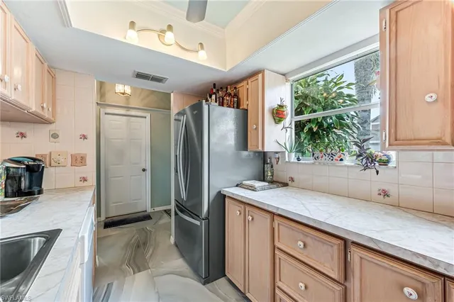 a kitchen with stainless steel appliances granite countertop a refrigerator and a sink