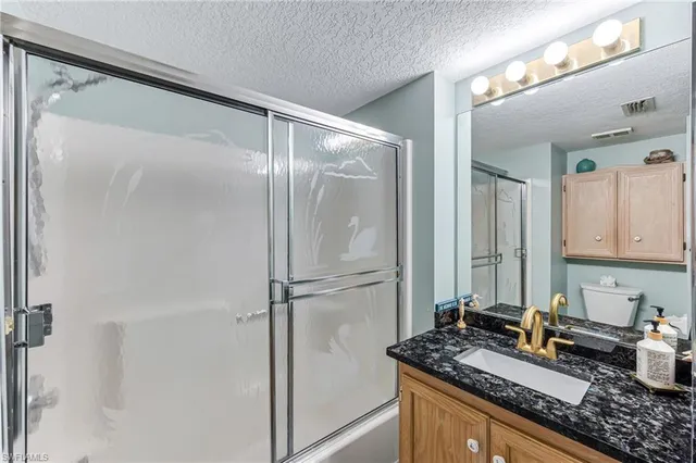 a kitchen with sink refrigerator and cabinets