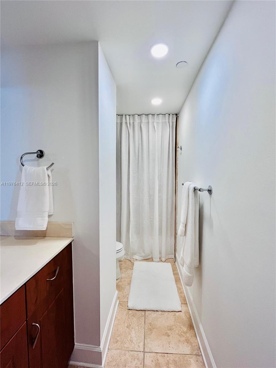 401 69th Street, Unit 405 Miami Beach, FL 33141 - Photo 11 of 20 a bathroom with a sink a mirror and a shower