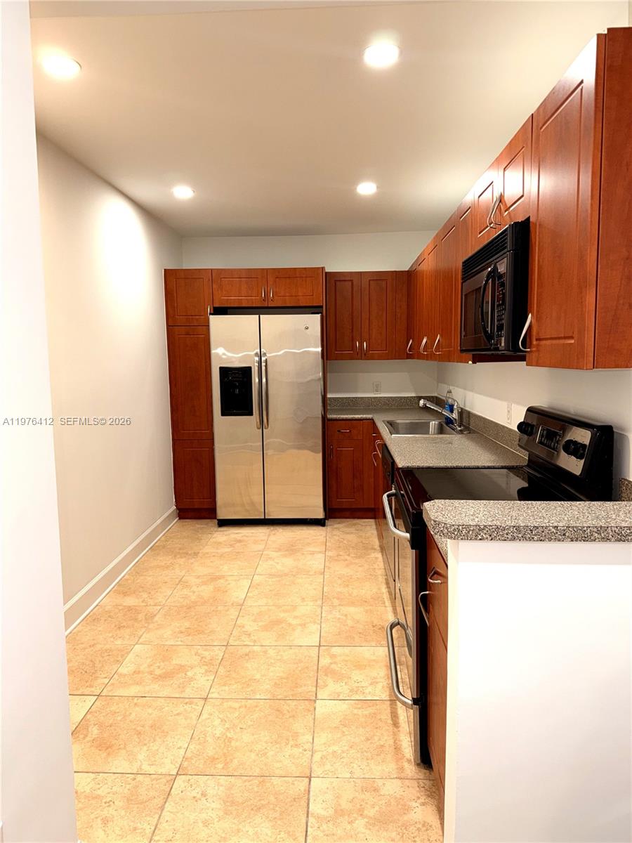 401 69th Street, Unit 405 Miami Beach, FL 33141 - Photo 5 of 20 a kitchen with stainless steel appliances granite countertop a sink and a refrigerator