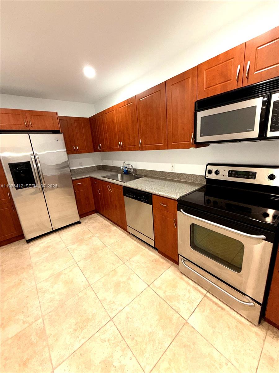 401 69th Street, Unit 405 Miami Beach, FL 33141 - Photo 6 of 20 a kitchen with stainless steel appliances a stove a microwave and sink