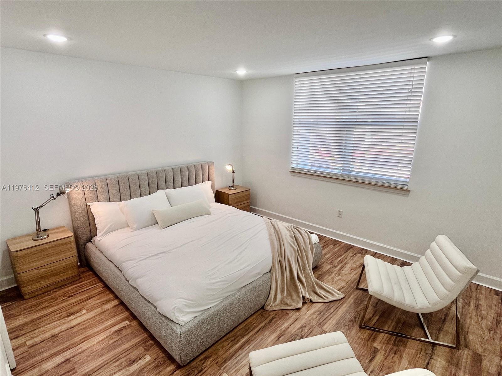 401 69th Street, Unit 405 Miami Beach, FL 33141 - Photo 7 of 20 a bedroom with a bed and chair