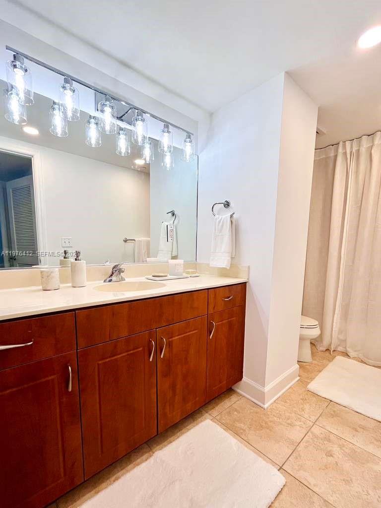 401 69th Street, Unit 405 Miami Beach, FL 33141 - Photo 9 of 20 a bathroom with a sink double vanity and a mirror