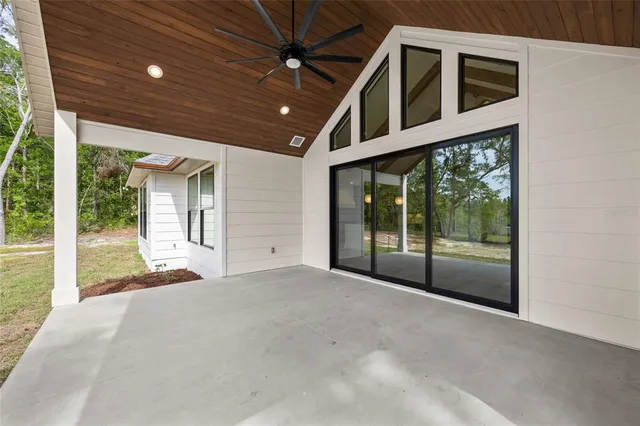 an aerial view of a house with a yard and a large tree