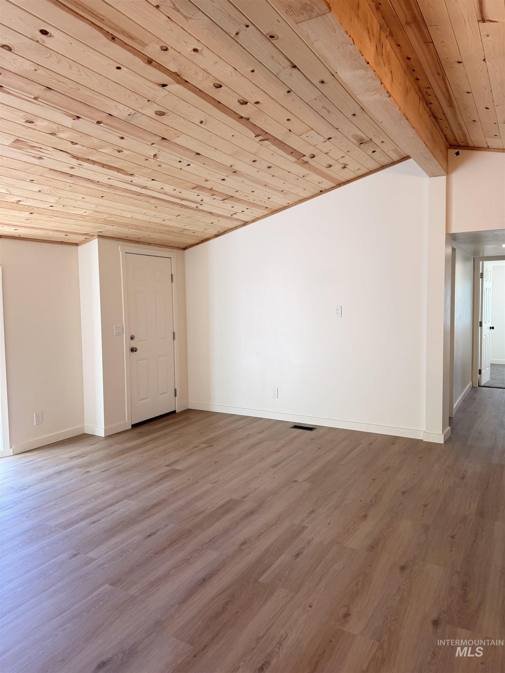 151 View Road Kamiah, ID 83536 - Photo 18 of 49 Open concept room featuring a wood-plank ceiling, exposed wood beam, wood-finish flooring, and white walls
