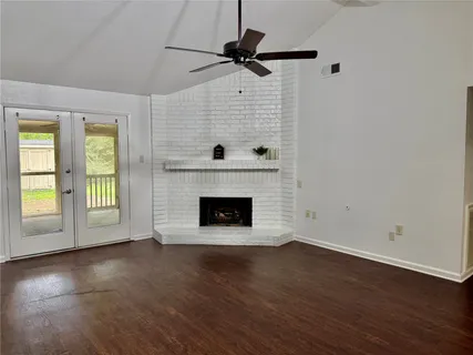a view of an empty room with a fireplace and a window