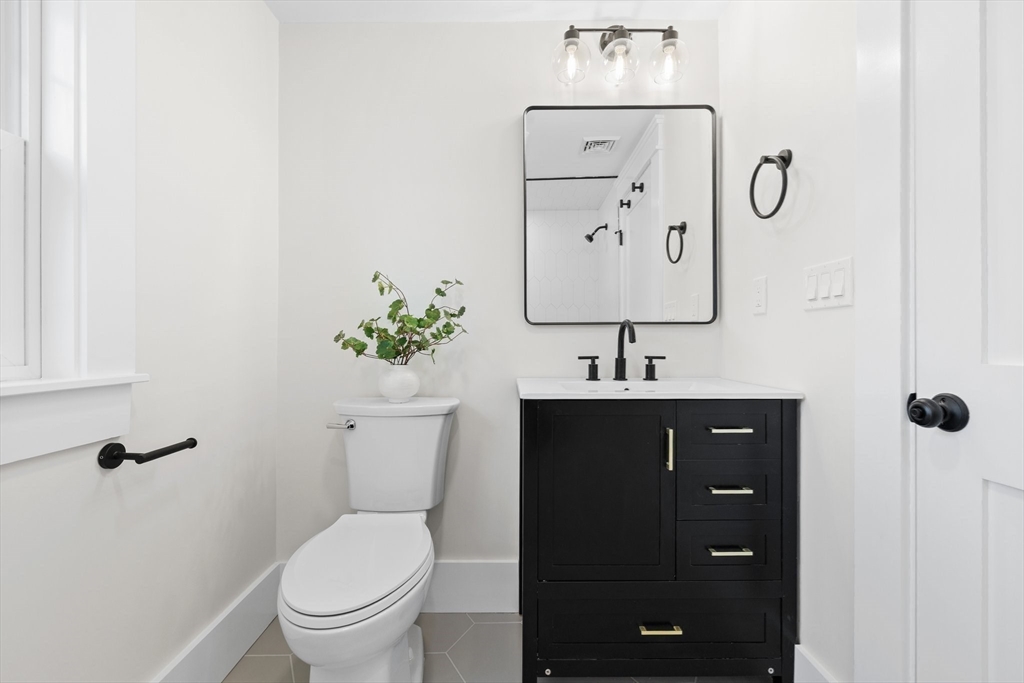 26 Holman Road Newton, MA 02466 - Photo 24 of 33 a bathroom with a toilet sink and mirror