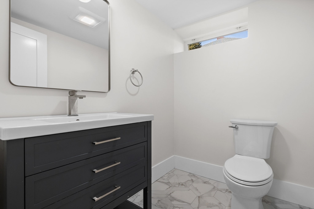 26 Holman Road Newton, MA 02466 - Photo 27 of 33 a bathroom with a toilet a sink and mirror