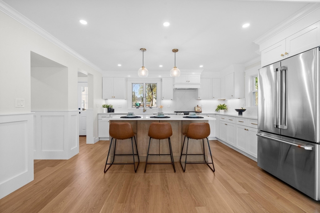 26 Holman Road Newton, MA 02466 - Photo 6 of 33 a kitchen with stainless steel appliances kitchen island granite countertop a dining table chairs and a refrigerator