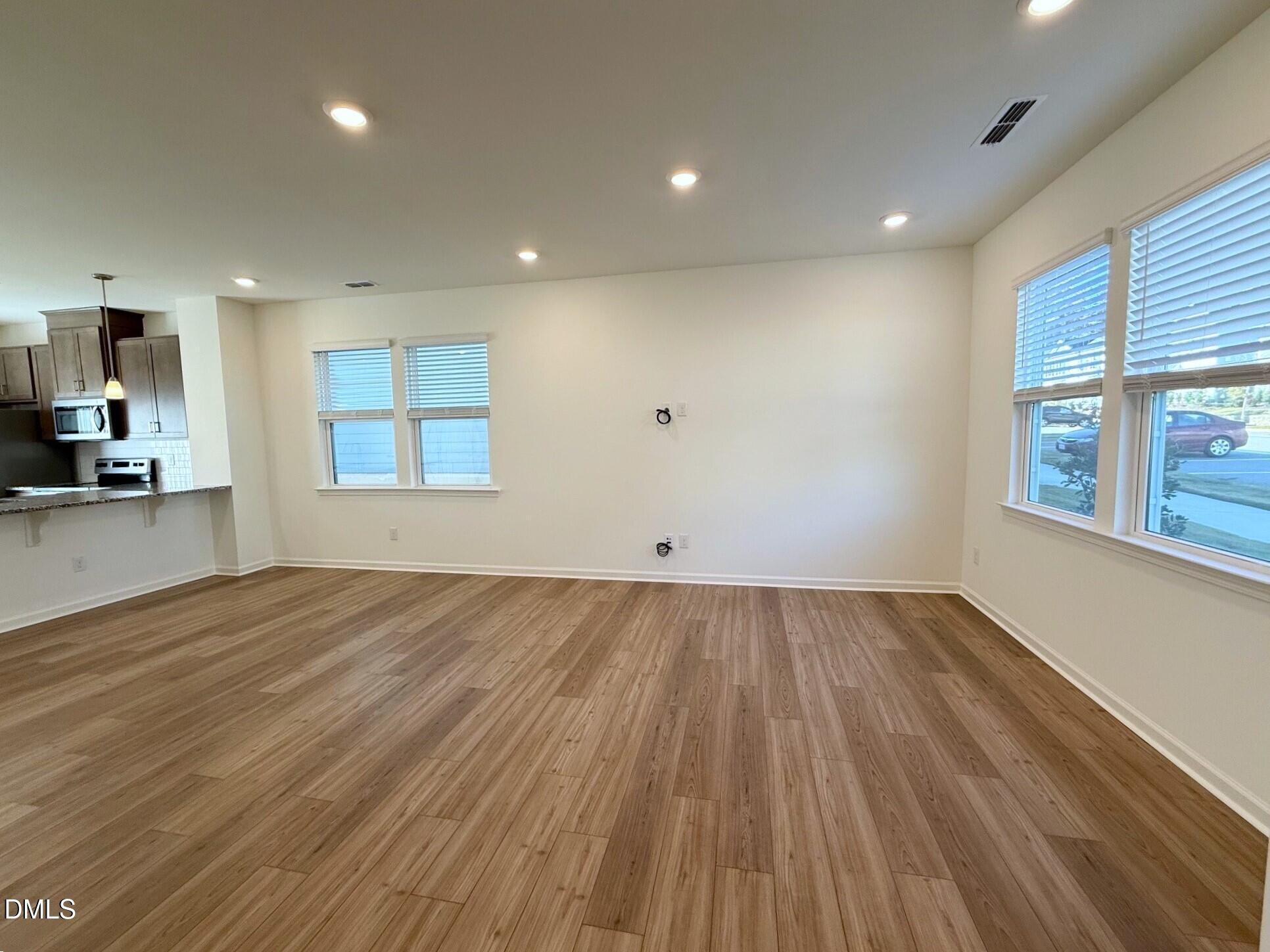 332 Hacksaw Trail Raleigh, NC 27610 - Photo 4 of 29 an empty room with wooden floor and windows