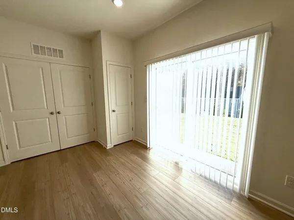 a view of empty room with wooden floor