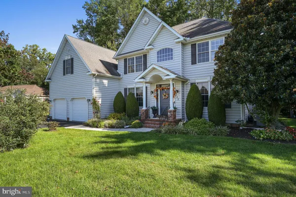 a front view of a house with a yard and trees