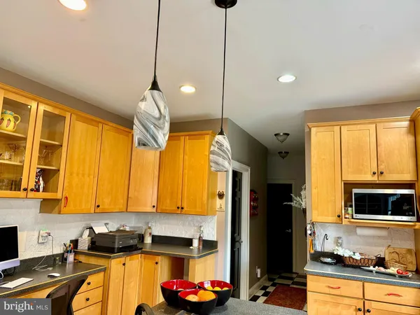 a kitchen that has a lot of cabinets stainless steel appliances and a window