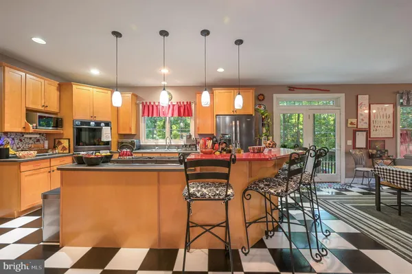 a kitchen with stainless steel appliances kitchen island granite countertop a sink and a cabinets