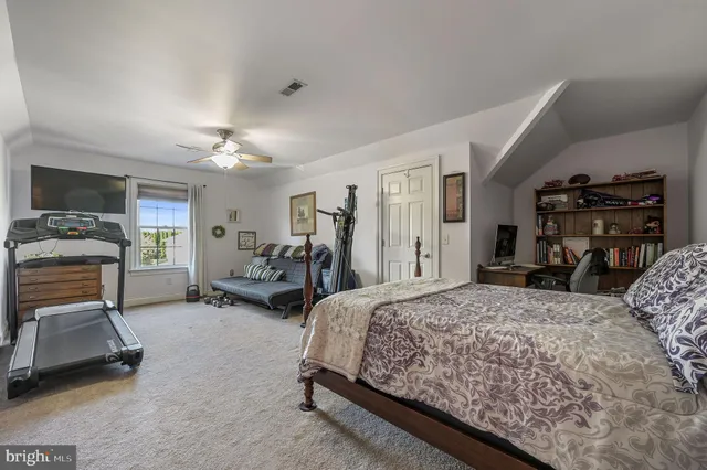 a bedroom with a bed a couch and chandelier