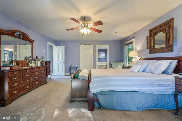 a bedroom with a bed a couch and chandelier