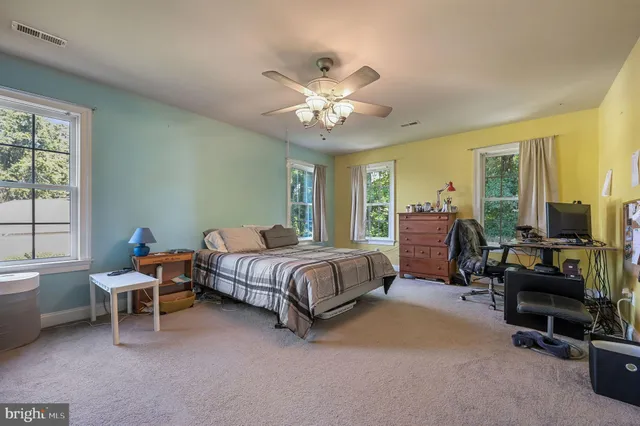 a spacious bedroom with a bed and a chandelier