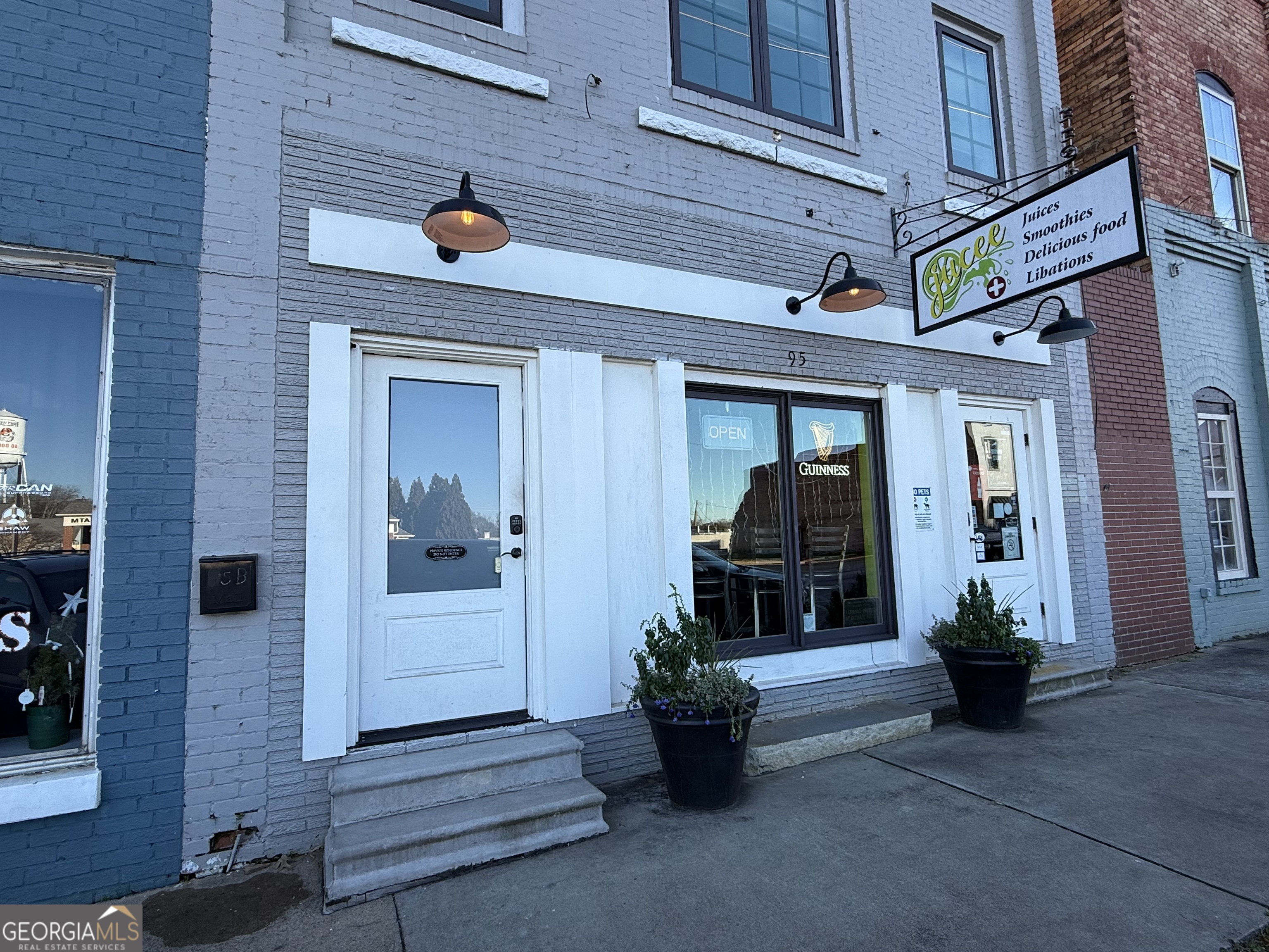 a front view of a house with barbeque potted plants