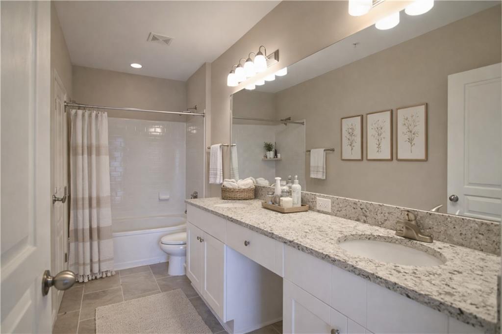 10 Perimeter Summit Boulevard, Unit 4139 Atlanta, GA 30319 - Photo 5 of 15 a bathroom with a granite countertop sink a toilet a large mirror and shower