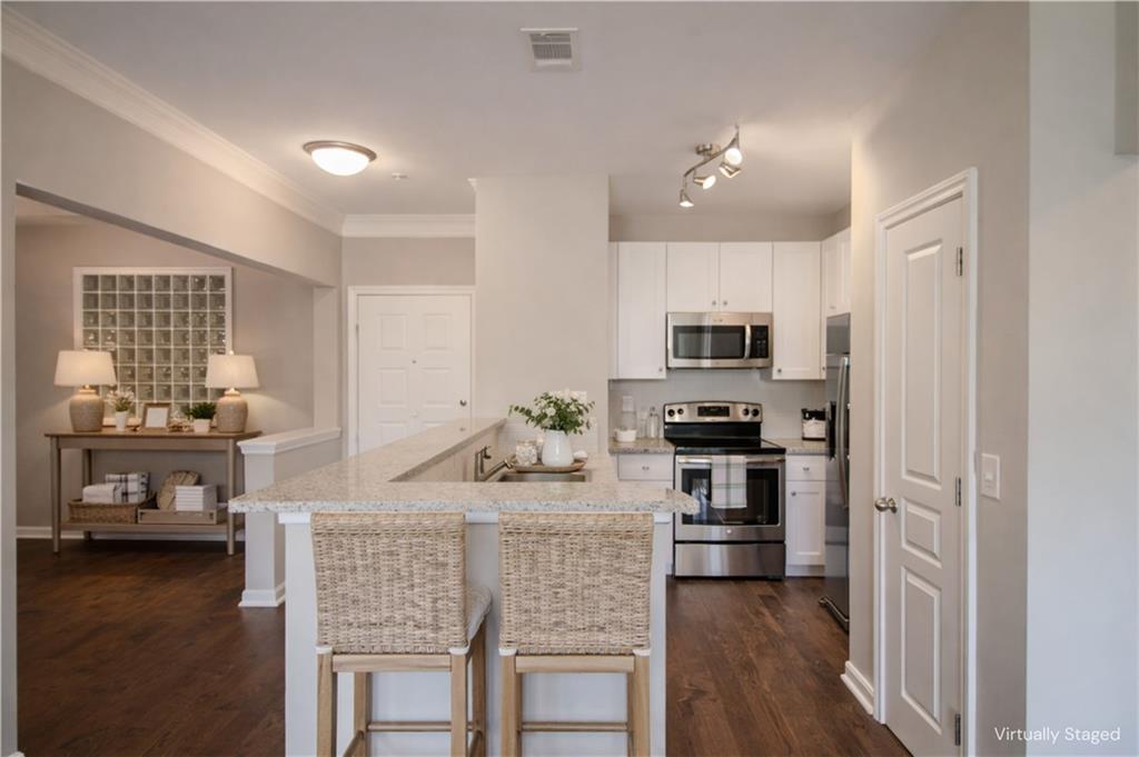 10 Perimeter Summit Boulevard, Unit 4139 Atlanta, GA 30319 - Photo 7 of 15 a kitchen with microwave a stove and cabinets