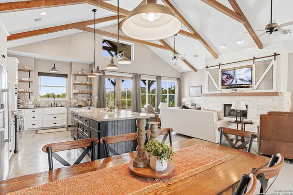 a dining room with wooden floor a chandelier a wooden table and chairs