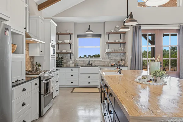 a kitchen with stainless steel appliances sink stove top oven and cabinets