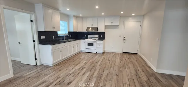 a kitchen with wooden floors and white appliances