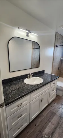 a bathroom with a granite countertop sink and a mirror