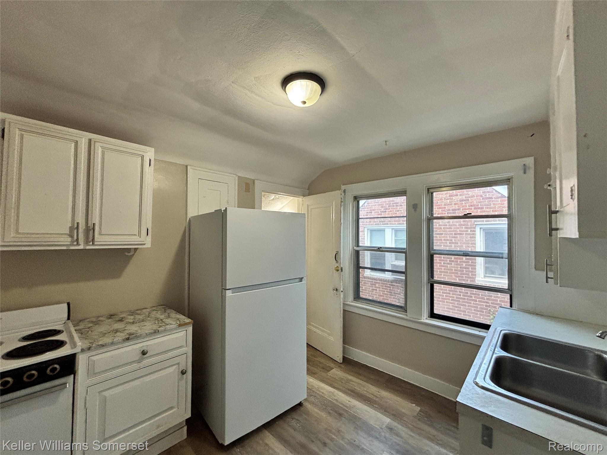 5783 Yorkshire Road Detroit, MI 48224 - Photo 2 of 13 Kitchen with white cabinetry, wood-finish flooring, and a double-basin stainless steel sink