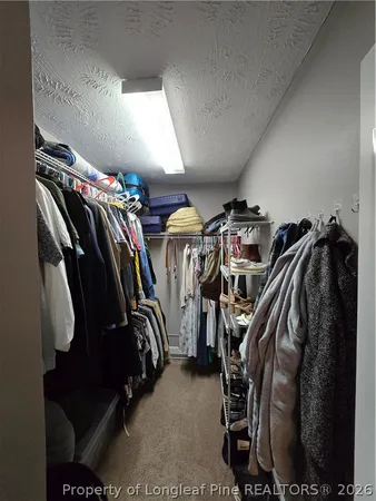 a view of walk in closet with clothes