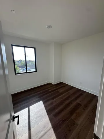 a view of bedroom with wooden floor and window