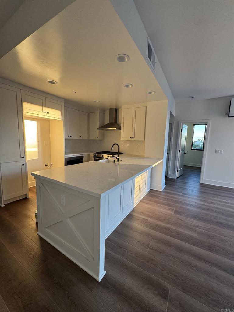 1105 Catania Court, Unit 201 Encinitas, CA 92024 - Photo 18 of 19 a living room with stainless steel appliances kitchen island granite countertop a sink wooden floor and view living room
