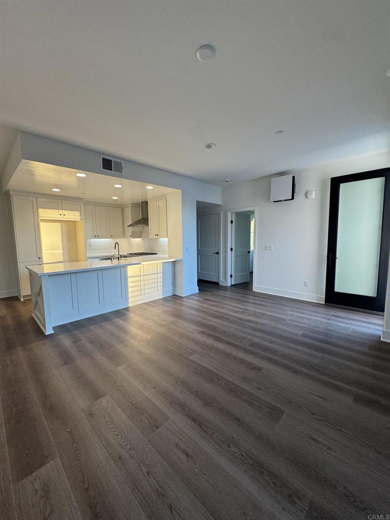 1105 Catania Court, Unit 201 Encinitas, CA 92024 - Photo 2 of 19 an empty room with wooden floor and windows