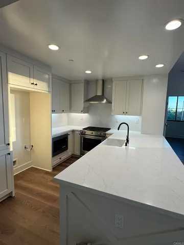 a large kitchen with stainless steel appliances a sink a stove and a refrigerator