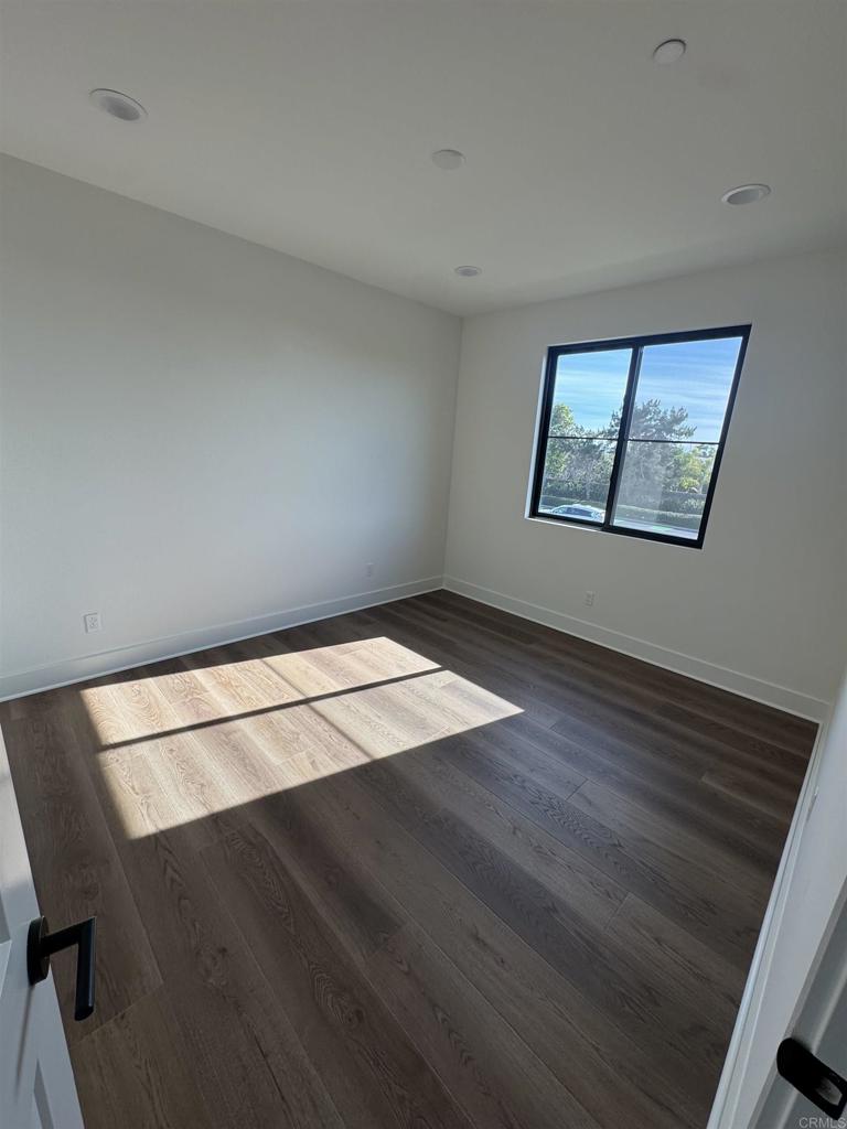 1105 Catania Court, Unit 201 Encinitas, CA 92024 - Photo 7 of 19 an empty room with wooden floor and windows