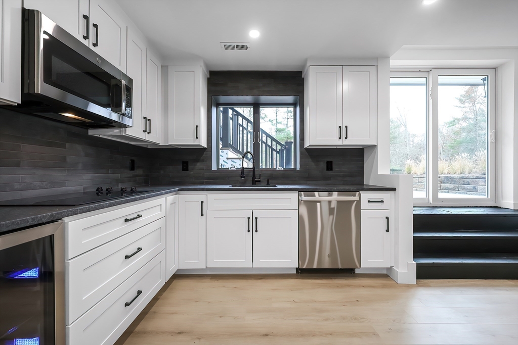 54 Spywood Road Sherborn, MA 01770 - Photo 34 of 42 a kitchen with stainless steel appliances granite countertop a stove a sink and a microwave