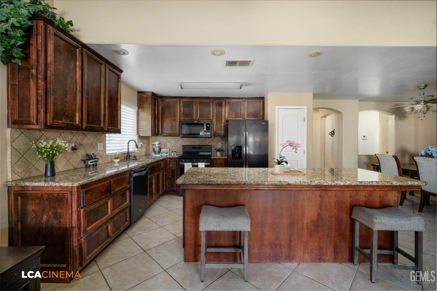 Undisclosed Address Bakersfield, CA 93312 - Photo 8 of 38 a kitchen with stainless steel appliances granite countertop wooden cabinets a sink and a stove