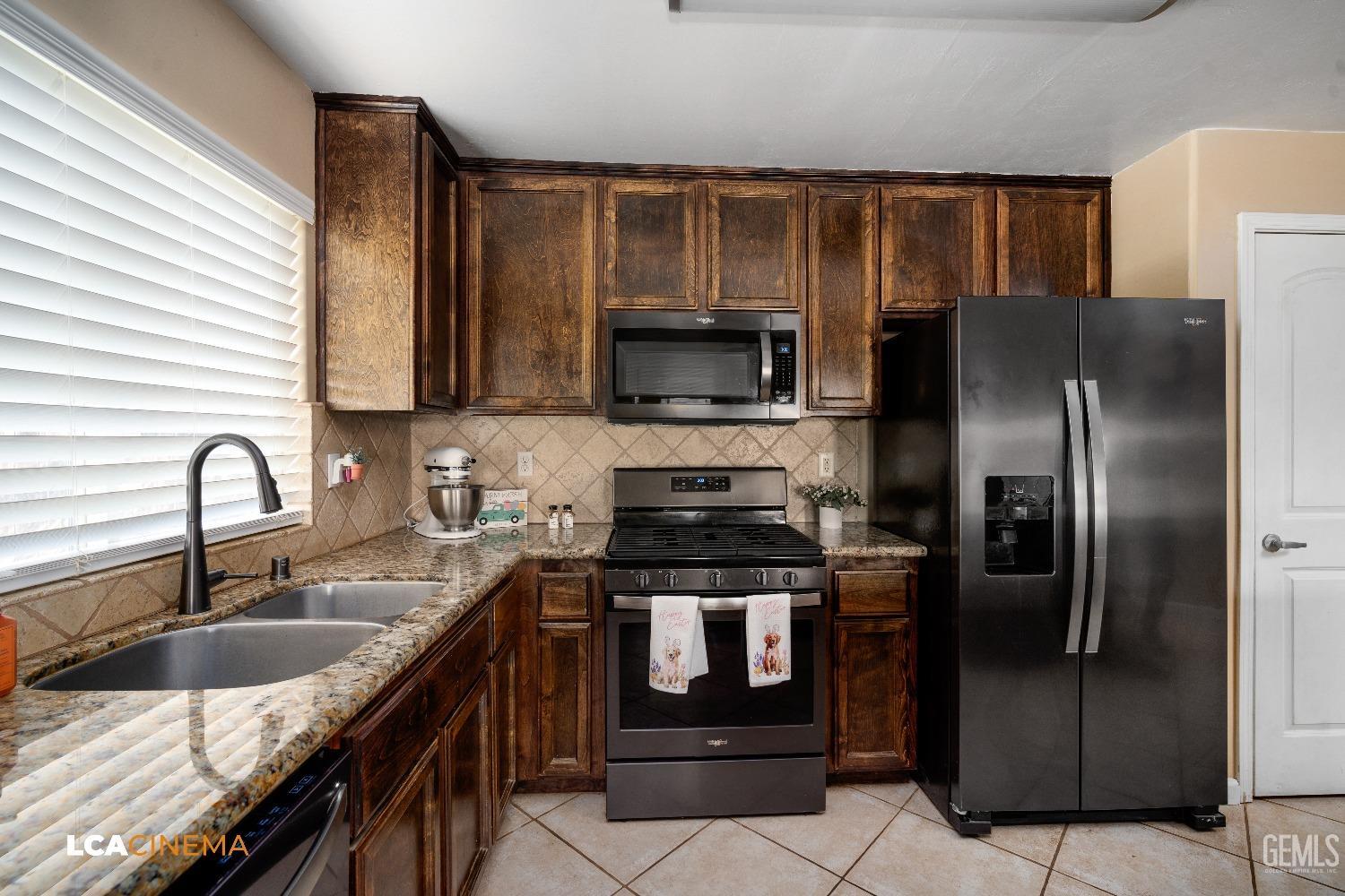 Undisclosed Address Bakersfield, CA 93312 - Photo 9 of 38 a kitchen with stainless steel appliances granite countertop a stove a sink and a microwave